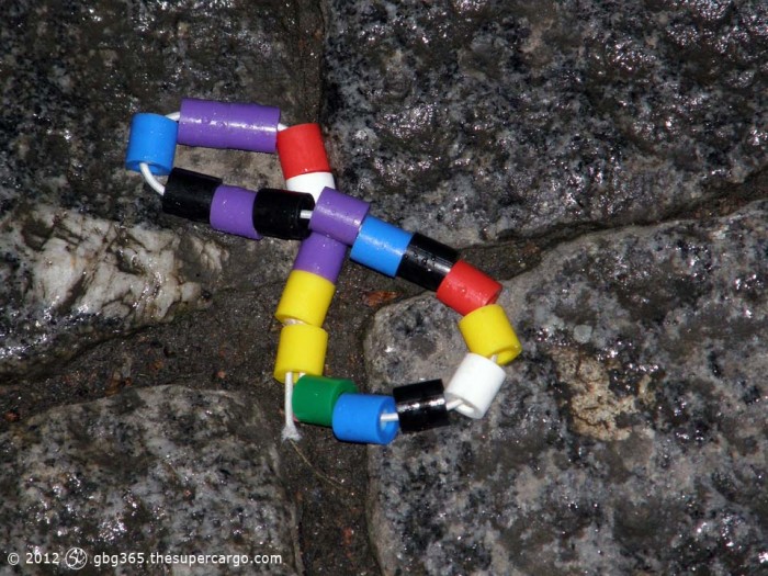 Child's wristband or bracelet of plastic cylindrical beads